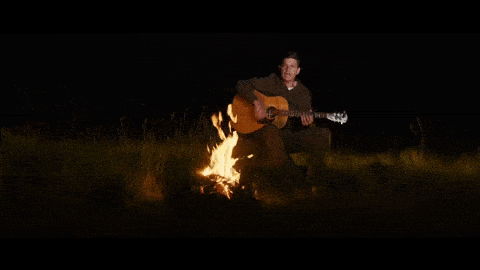 Playing guitar around the campfire.